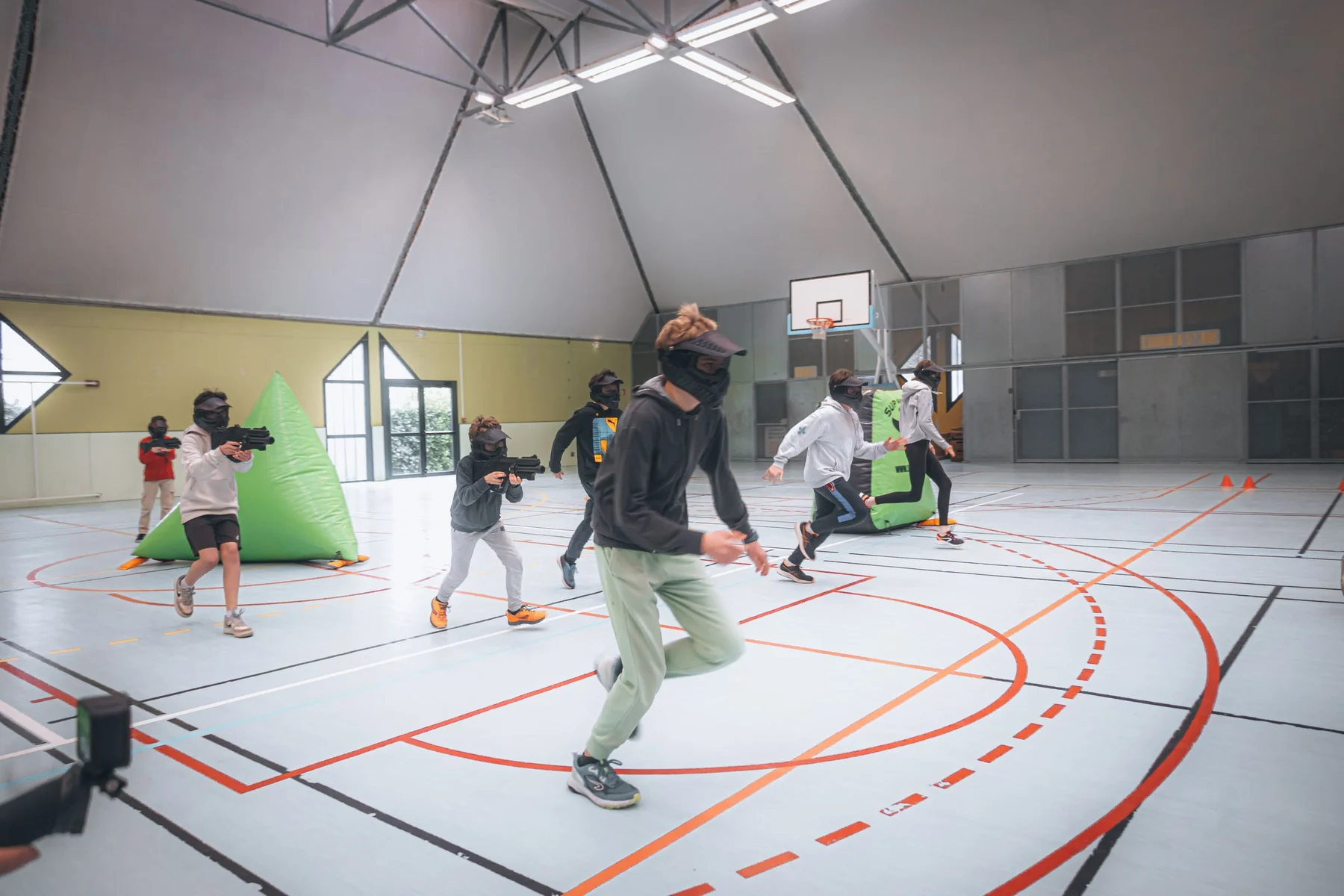 Uczestnicy w trakcie zespołowej gry laser tag